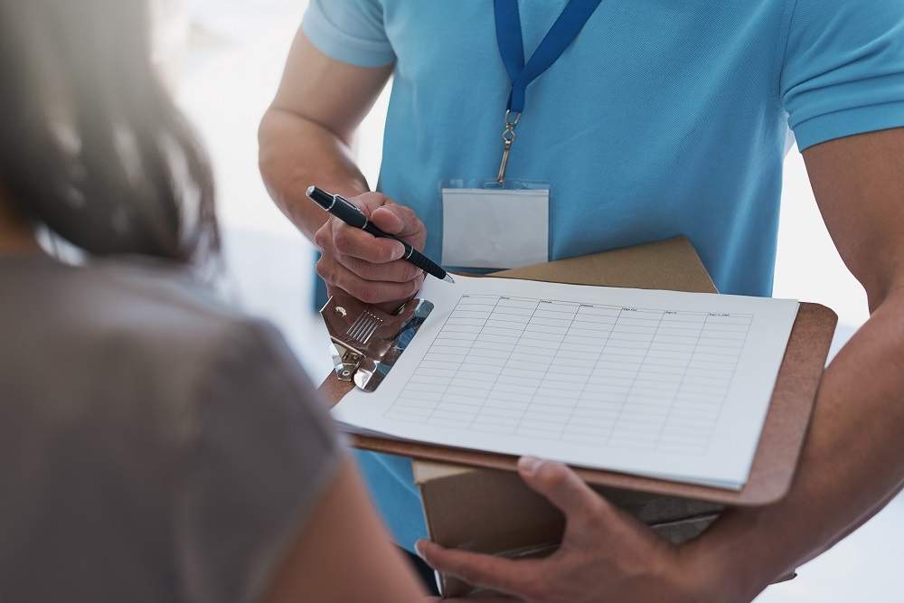 Cropped shot of a courier making a delivery to a businesswoman in her office